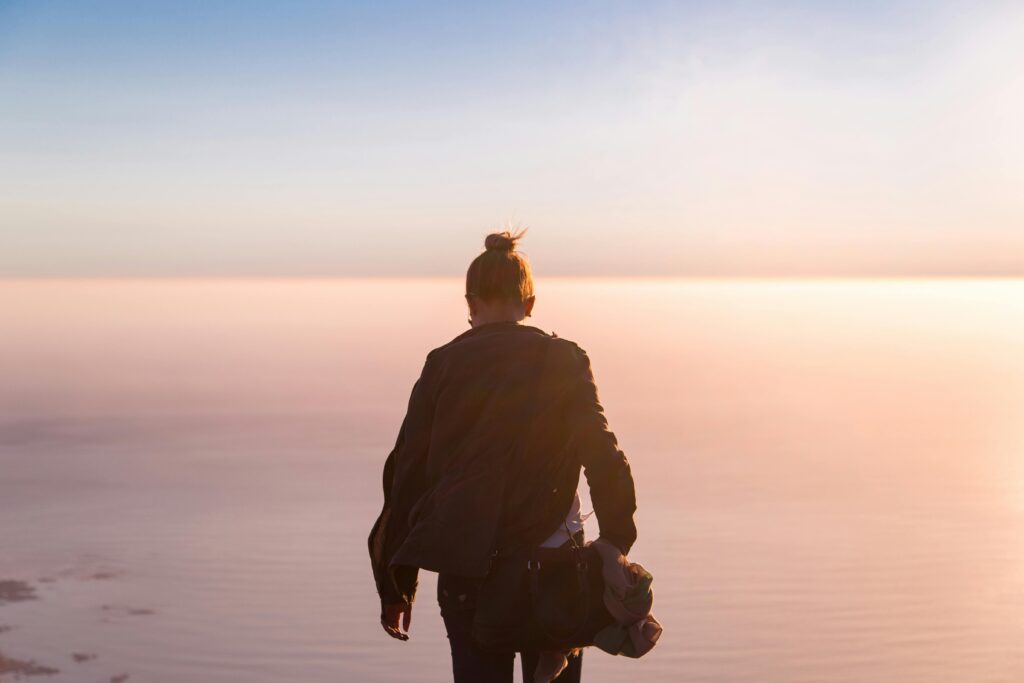 Дівчина стоїть спиною на заході сонця: метафора подолання синдрому самозванця